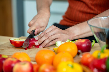 Hand chef knife cut and slice fresh Vegetables baby cos salad on wood board table .Make Salad Organic Vegetables mix lunch with green vegetables and fruit at kitchen table on wood cutting board.