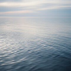 Tranquil subtle ripples on vast calm ocean water at dusk