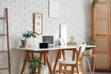 Workplace with laptop and aroma diffuser on desk in office