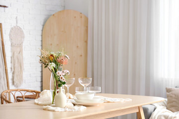Beautiful table setting with bouquet of flowers in light dining room