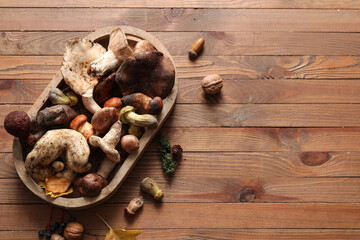 Tray with fresh mushrooms on wooden background