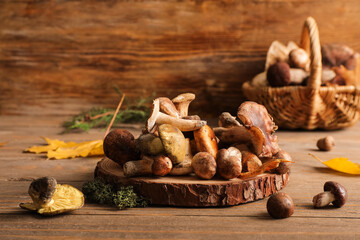 Wooden stand with fresh mushrooms and green moss on wooden table, closeup