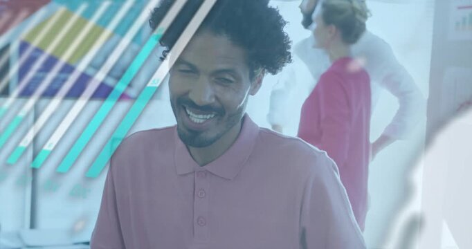 Man reviewing business data, writing notes and smiling as screen showing charts and globe overlays
