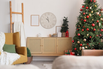 Naklejka premium Interior of festive living room with Christmas tree, brown armchair and clock