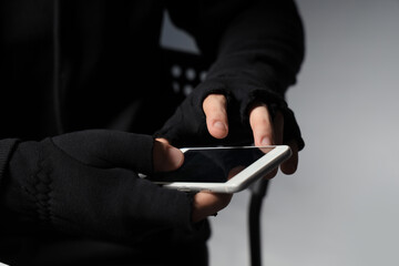 Male fraudster with mobile phone on dark background, closeup
