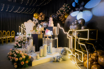 Elegant quinceañera party decoration with golden, black, and silver balloons