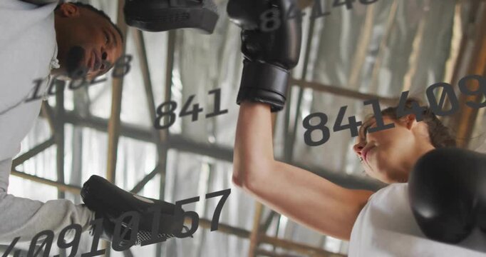 Coach holding mitts cueing boxer throwing combos for fitness under roof with overlay tracking boxer