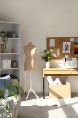 Interior of atelier with mannequin, tailor's workplace and shelf unit