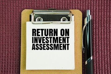 Pen and paper board with the words Return on Investment Assessment. a financial ratio used to calculate the benefit an investor will receive in relation to their investment cost.