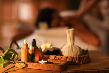 Spa composition with massage oils on table in dark salon, closeup