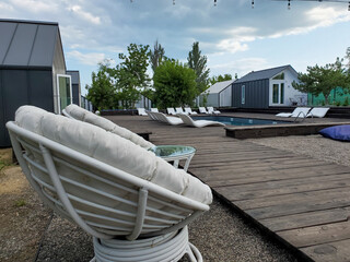 White cocoon chairs for outdoor recreation near the pool, glamping
