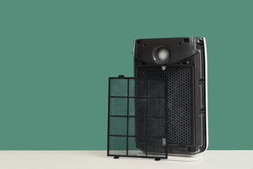 Obraz premium Disassembled air purifier with dirty filter on green background