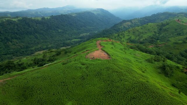 A wide pull-out aerial of Quinawan Valley revealing layered greenery, winding ridges, and forested slopes in Bataan, Philippines