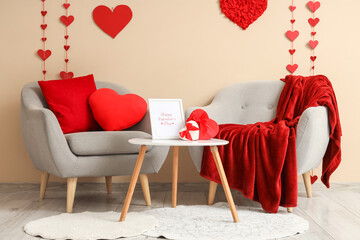 Interior of festive living room with grey armchairs, coffee table and hearts. Valentine's Day...