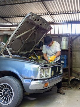 man repairing an old car