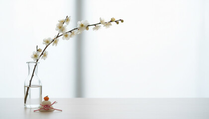 ガラス花瓶に飾られた白い梅の花と水引の和風お正月イメージ