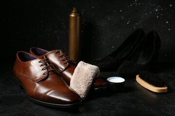 Shiny leather shoes, cloth, brush and shoe polish on black background