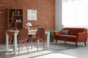 Interior of light living room with table, chairs, sofa and shelving unit