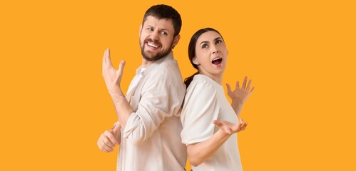 Angry young couple quarreling on yellow background