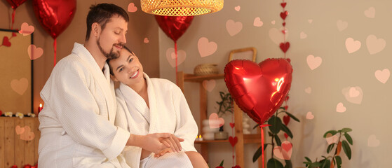 Young couple sitting in dark spa salon on Valentine's Day