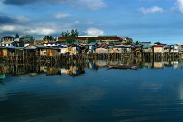 view of stilt houses and boats in the harbor