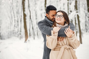 Portrait of a romantic couple spending time together in winter forest