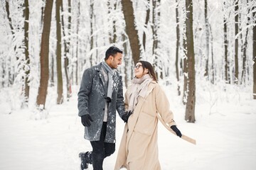 Portrait of a romantic couple spending time together in winter forest