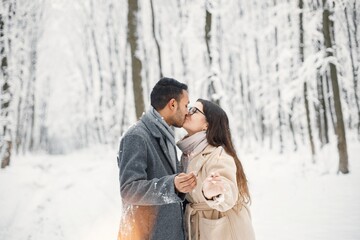 Portrait of a romantic couple holding a sparkle in winter forest