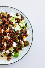 healthy nourish bowl with spicy vegan mince, avocado, olives, cucumber and hummus