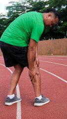 Fototapeta premium Young adult male with his muscle pain during running. runner man having leg ache due to Shin Splints. Sports injuries and medical concept