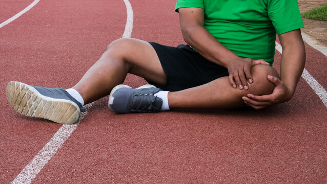 Young adult male with muscle pain during running. runner have knee ache due to Runners Knee or Patellofemoral Pain Syndrome