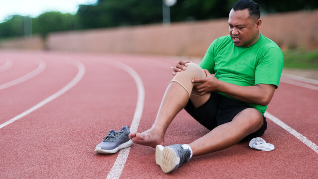 Young adult male with muscle pain during running. runner have knee ache due to Runners Knee or Patellofemoral Pain Syndrome