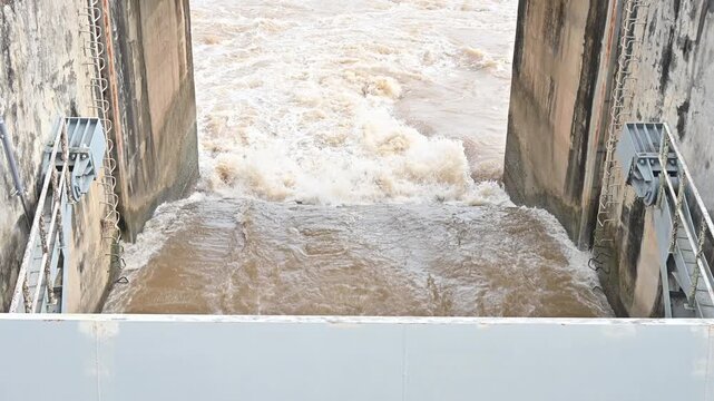 Spillway of Chiang Rai dam open for release water. Spillway, passage for surplus water over or around a dam when the reservoir itself is full.