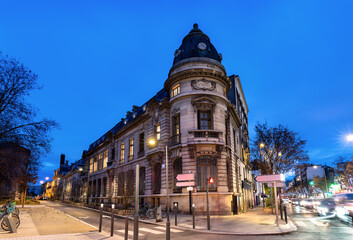 Historic administrative building stands on a street corner in Saint-Ouen-sur-Seine near Paris, France. Eclectic architecture features a stone facade and slate dome with "St Ouen" inscription