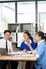 A lone Asian male doctor is working in a hospital conference room.