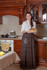 Woman holding plate of pies on flour skirt