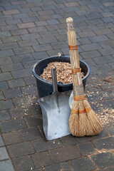 Bucket of sawdust stands in cleaned yard