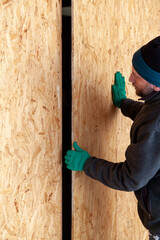 Man with beard sets up large wooden sheet