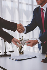 People shaking hands and exchanging money in legal office