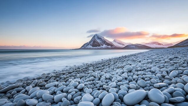 Serene landscape of snow covered mountains and rocky beach at sunset with calm sea and vibrant sky - Powered by Adobe