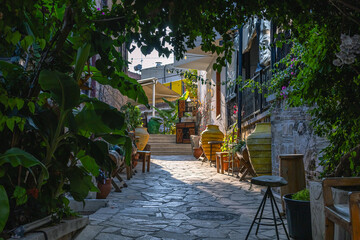 The old courtyard hides behind the flowering trees during the hot summer. There are large ceramic vessels in the courtyard of the house. The interior of an old house in the Kaleici district.