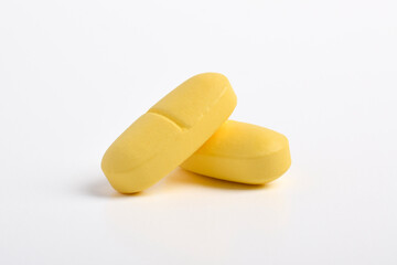 Two yellow capsule pill isolated on white background