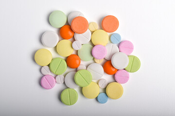 Various colorful pills on white background, displaying various medicines, vitamins and supplements for healthcare and pharmacy concept.