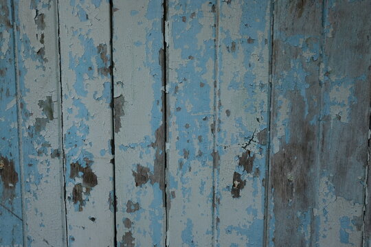 Weathered blue paint on old wooden planks creates a rustic background