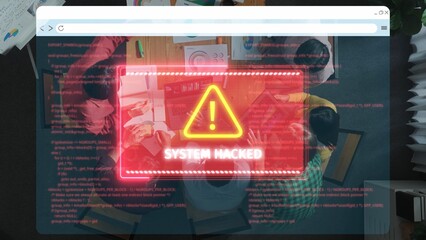 An overhead view showing a team in an office setting, discussing cybersecurity while a computer displays a critical alert about a system breach, conveying urgency and awareness. Raster