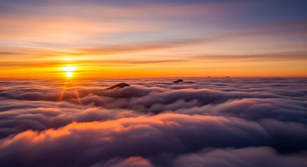 Fototapeta premium Brilliant sun illuminates vast layer of low clouds above mountain peaks at sunrise