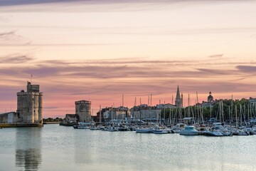 Fototapeta premium Explore La Rochelle, France, with its picturesque harbor. Enjoy views of historic towers, boats, and stunning sunsets. A perfect destination in Nouvelle-Aquitaine for travelers.