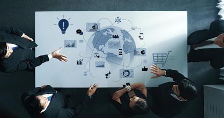 Business professionals collaborating over a strategy session at a conference table with global data analysis and tech graphics on display Trope.