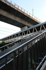 Obraz premium Modern pedestrian bridge with stairs and elevated walkway