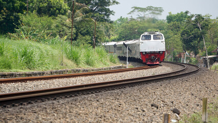 A fast-moving train glides smoothly along the railway tracks, showcasing power, motion, and precision in transportation © AntxPhotoStock